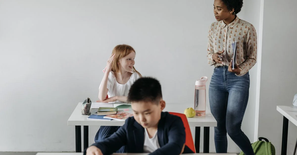 Enseignant aidant des étudiants divers dans un environnement de classe, promouvant l'éducation et l'apprentissage.